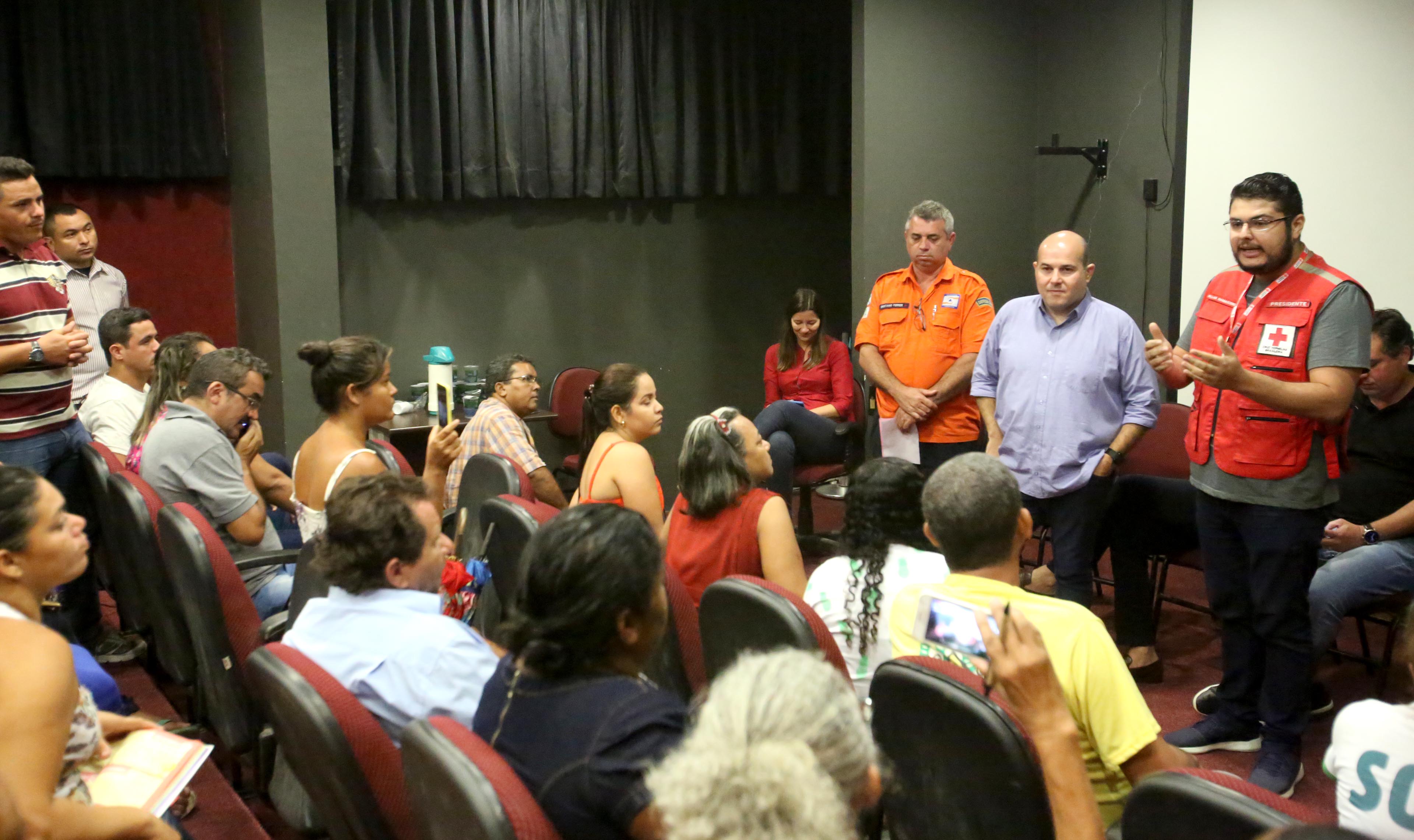 várias pessoas numa sala. Algumas estão sentadas, outras em pé